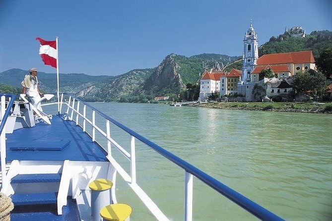 The deck of a Danube boat flying the Austrian flag, with Dürnstein ahead