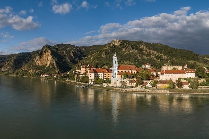 Dürnstein on the riverbank below its rocky, wooded hill