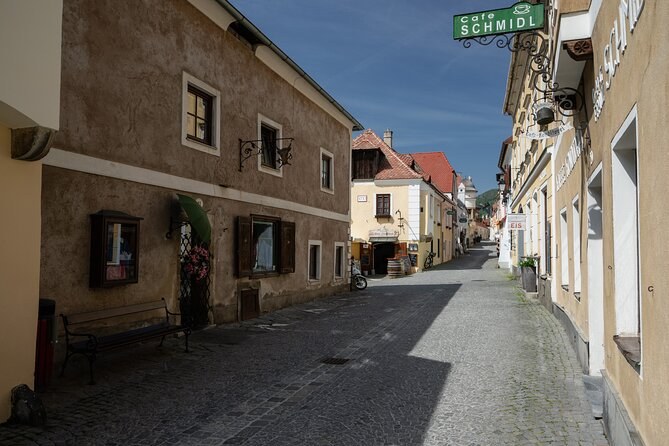 A cobbled lane of old houses in Dürnstein, with iron shop signs