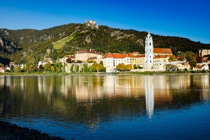 Dürnstein and its hillside reflected in the Danube on a clear morning