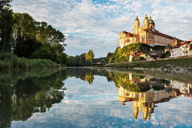 Melk Abbey on its rock above the trees, reflected in still water below